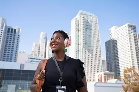 A woman wearing headphones walks through 贝博体彩app的 SoMa neighborhood.