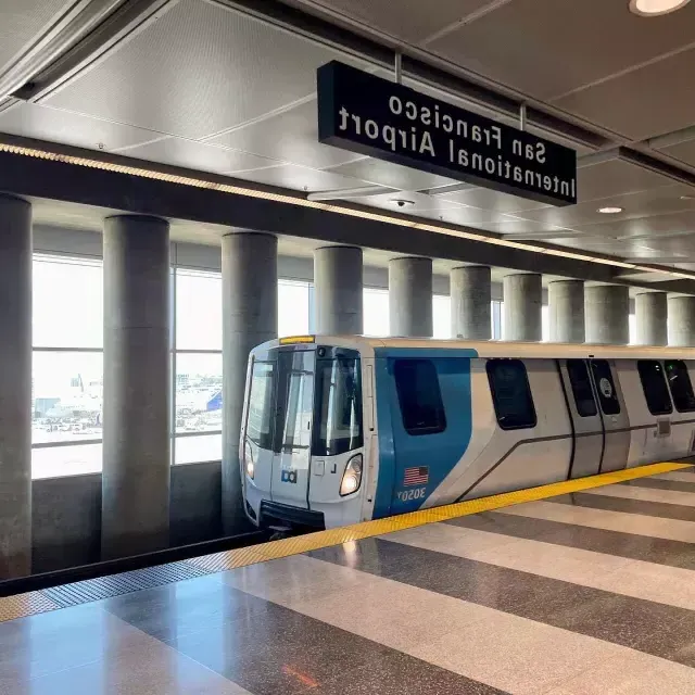 A BART train waits for passengers at 的 station.